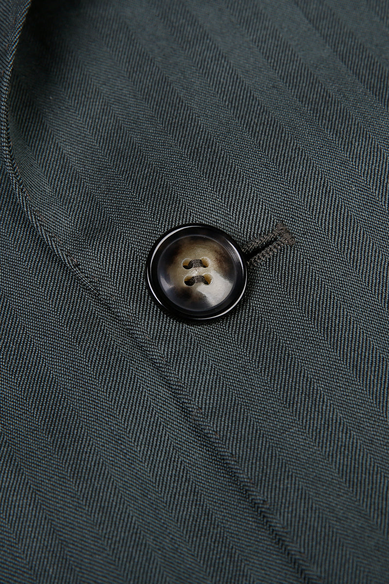 Custom jacket button on tailored forest green herringbone suit