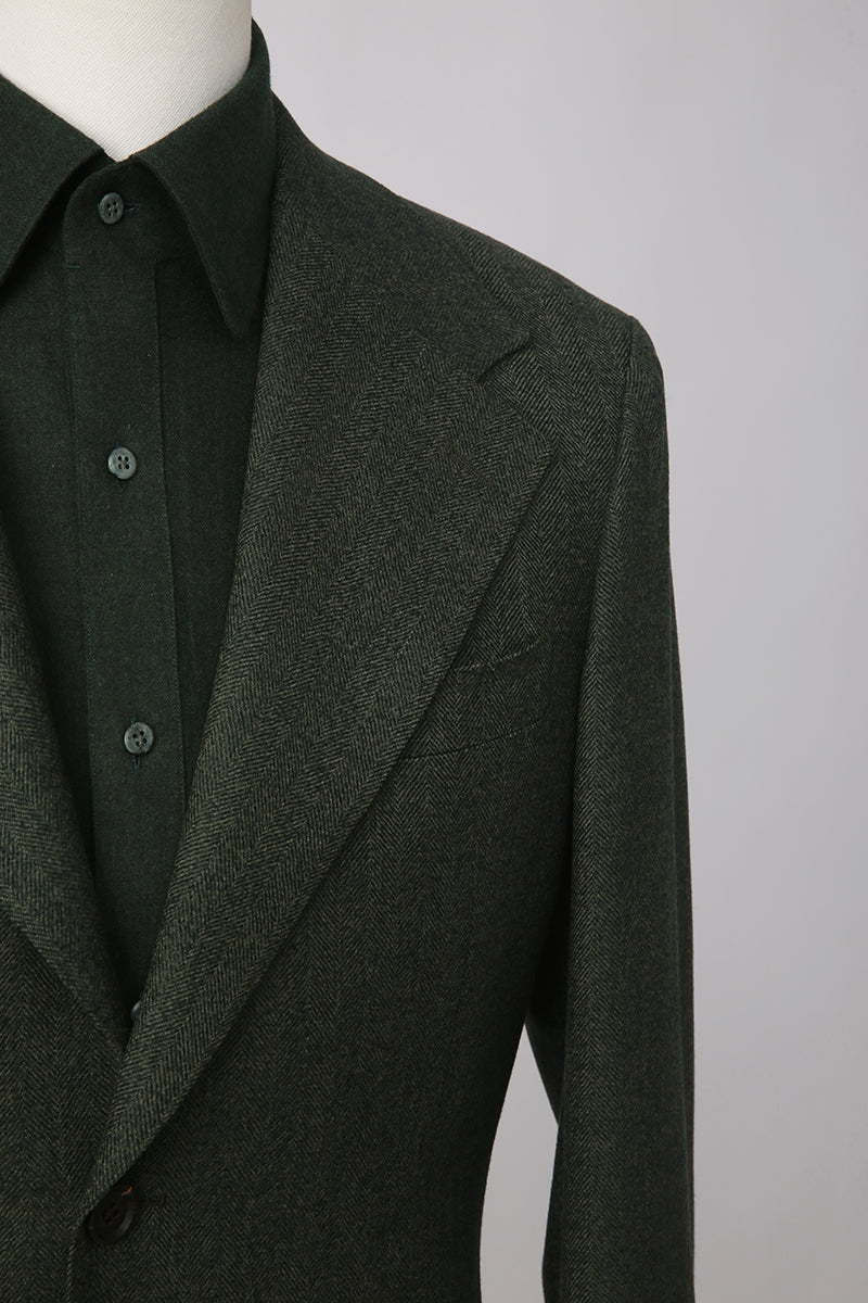 Custom lapel and buttons on tailored dark green herringbone blazer
