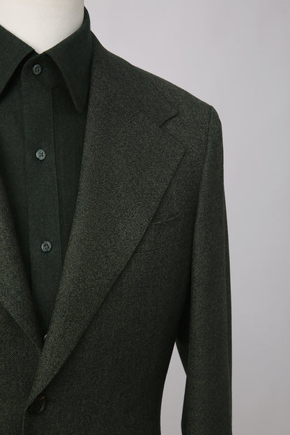 Custom lapel and buttons on tailored dark green herringbone blazer