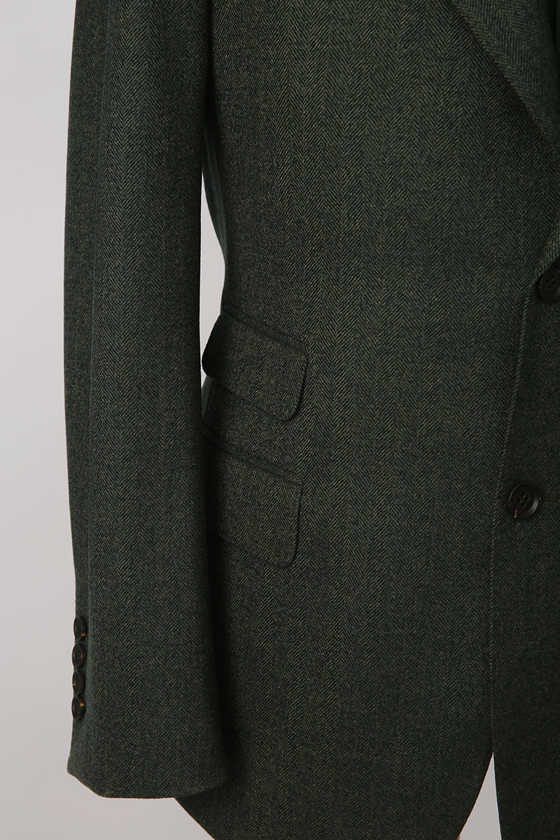 Custom sleeve buttons on tailored dark green herringbone blazer with ticket pocket