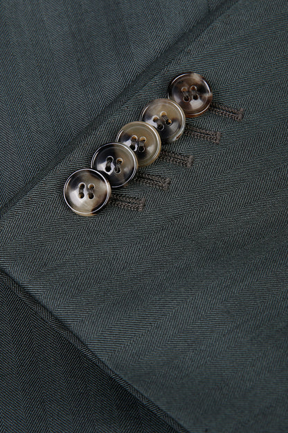 Custom sleeve buttons on tailored forest green herringbone suit