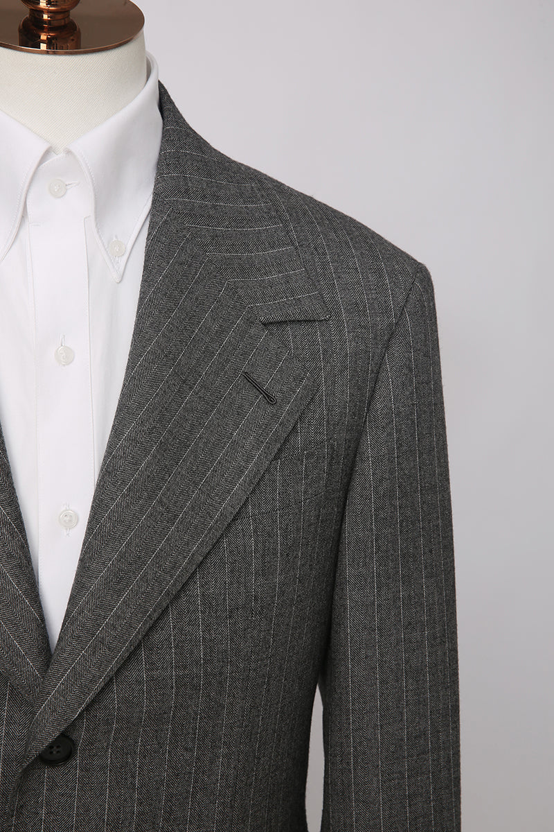 Custom lapel and buttons on tailored grey herringbone blaze