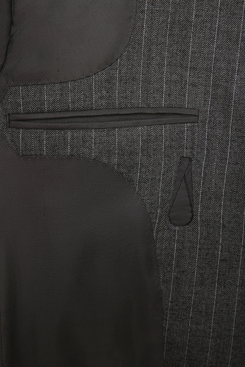 Luxury herringbone fabric texture on bespoke men’s jacket close up on pocket detail