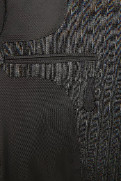 Luxury herringbone fabric texture on bespoke men’s jacket close up on pocket detail