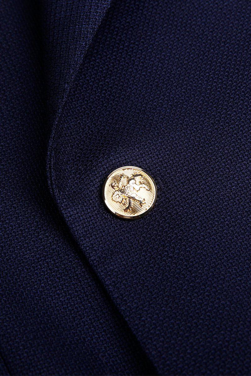 Custom gold statement buttons on tailored navy blue double-breasted blazer